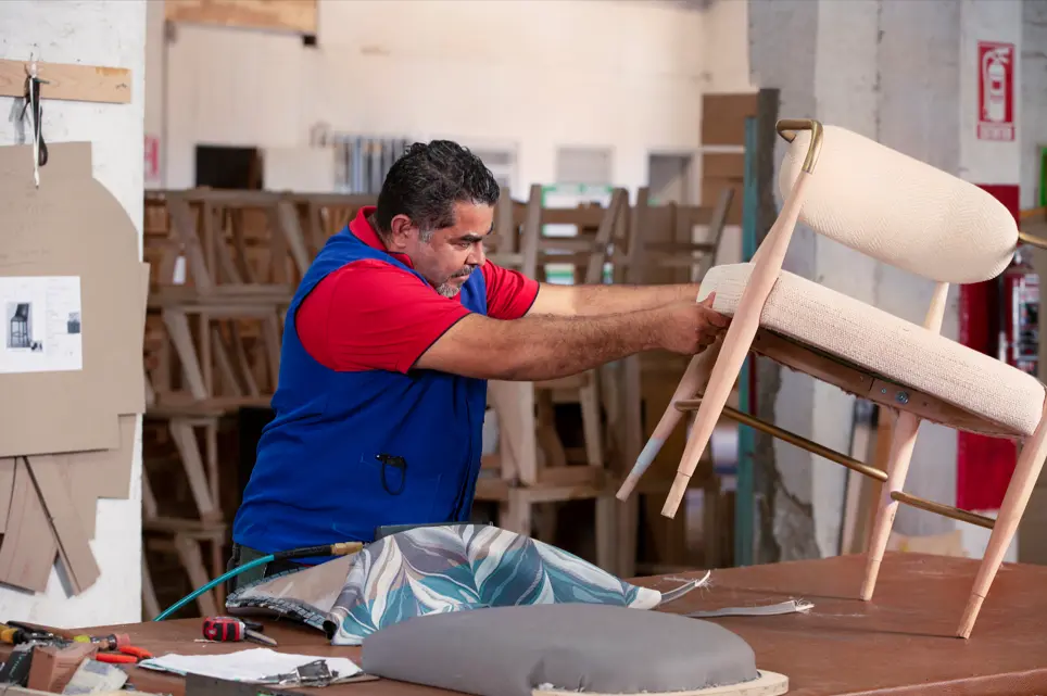 Image of an AG Employee finishing a chair